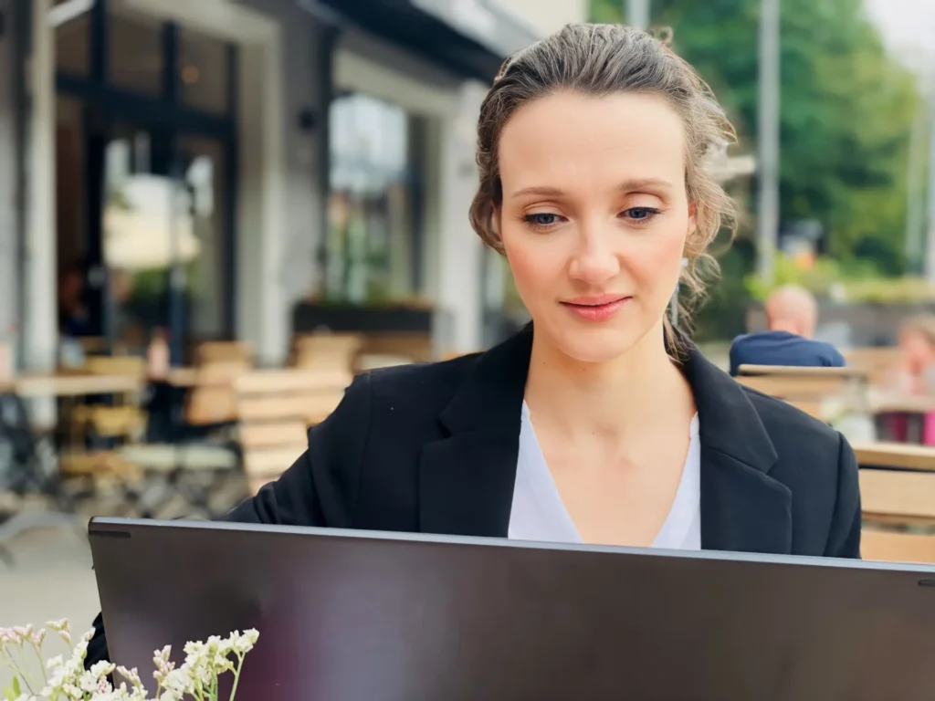 Digital Marketing Expertin | Nahaufnahme: Im Cafe sitzen und am Laptop arbeiten